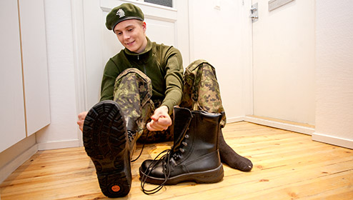 A conscript is tieing shoes.